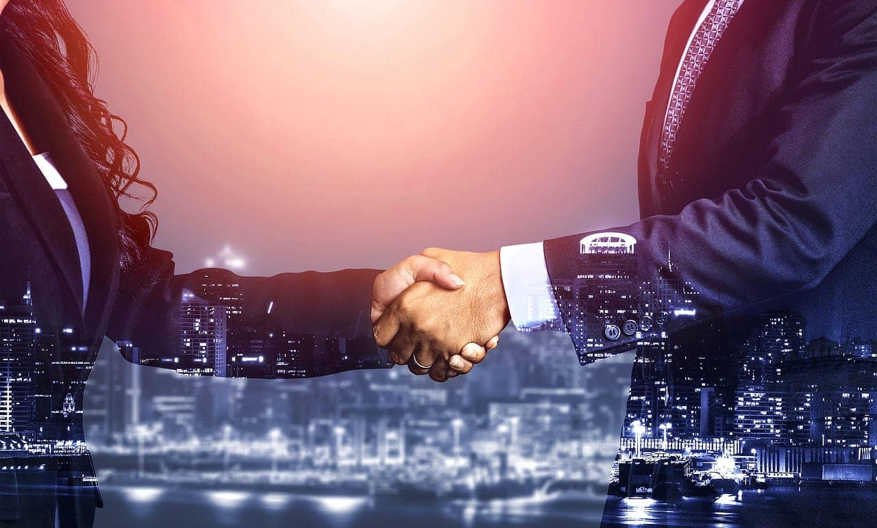 Joint venture agreement handshake between local and foreign business partners